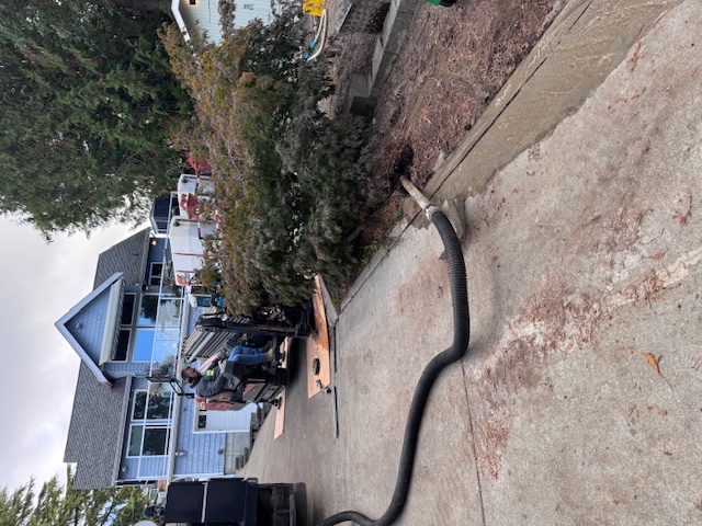 Directional Boring Services performed by Rush Plumbing - man on equipment with long hose in driveway